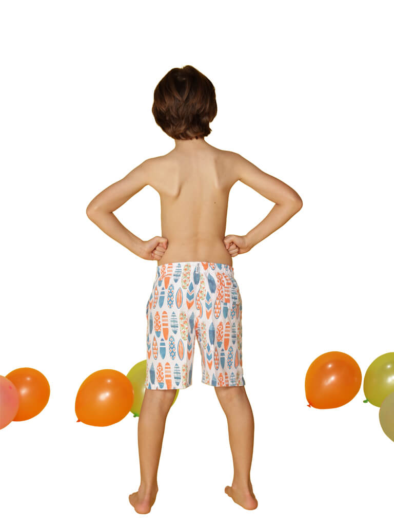 Boy's board trunks patterned in surfboards, back view